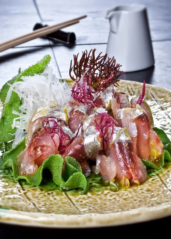 A colorful sashimi platter with tuna, salmon and garnishes