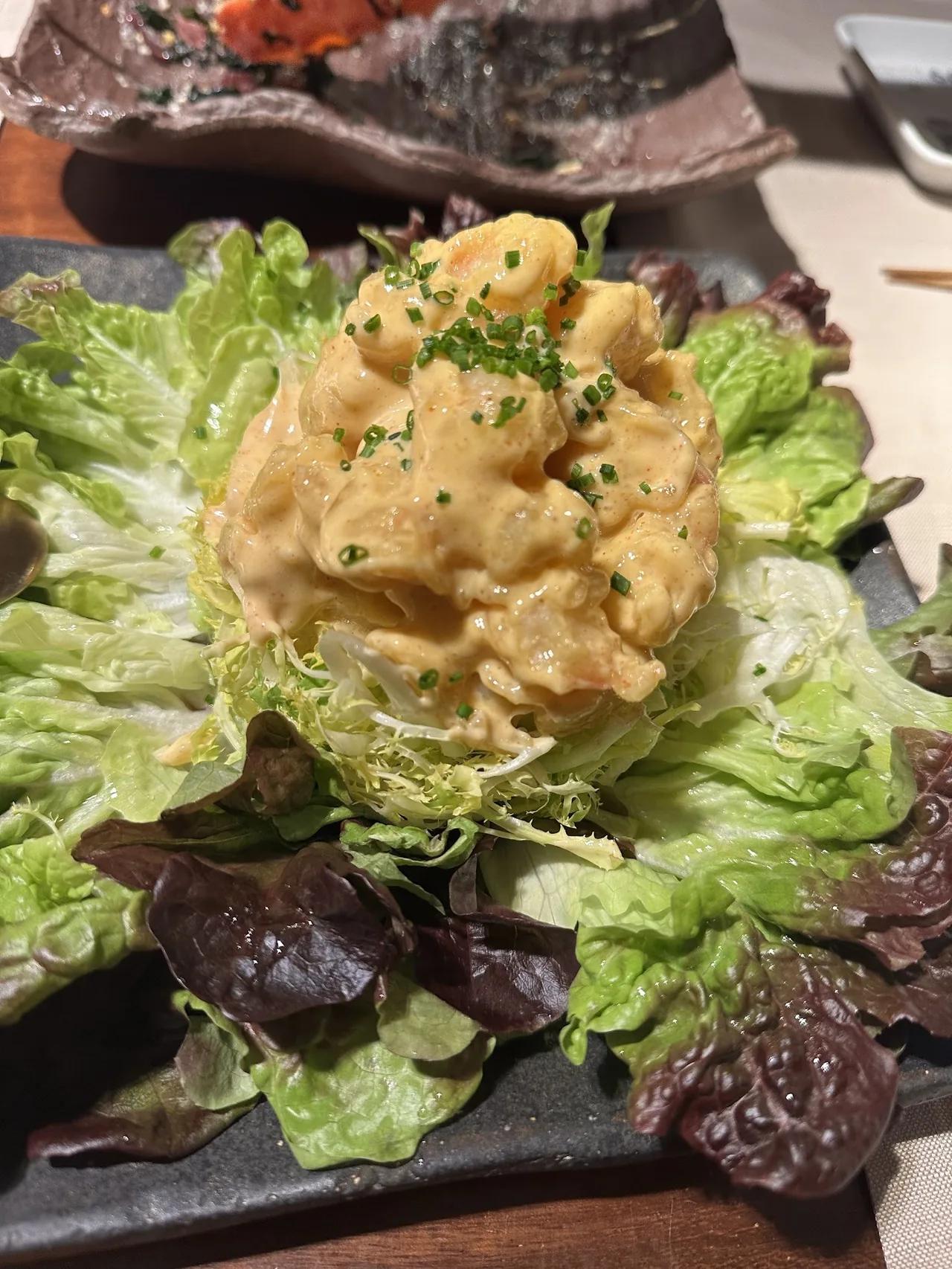 A mound of creamy topping on a lettuce salad