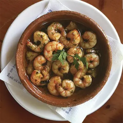 Garlic shrimp (gambas al ajillo) in olive oil with parsley, served in a terracotta dish, A Gudiña