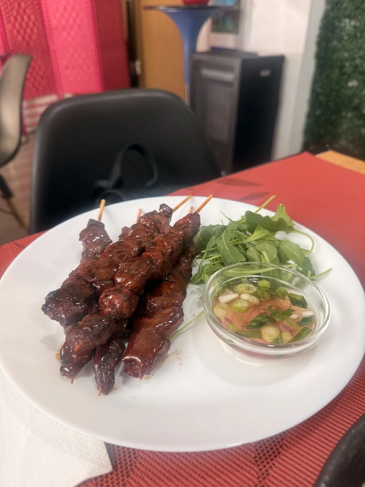Grilled meat skewers served with a side salad