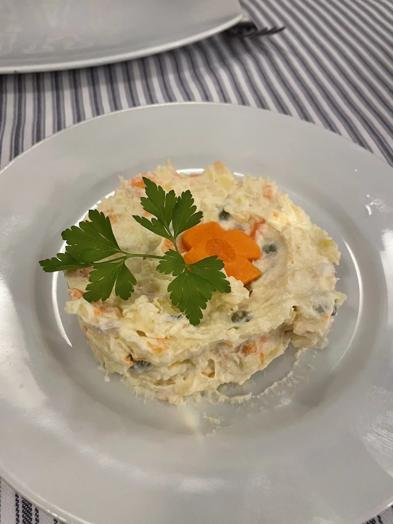 A plate of seafood salad with mayonnaise garnished with parsley