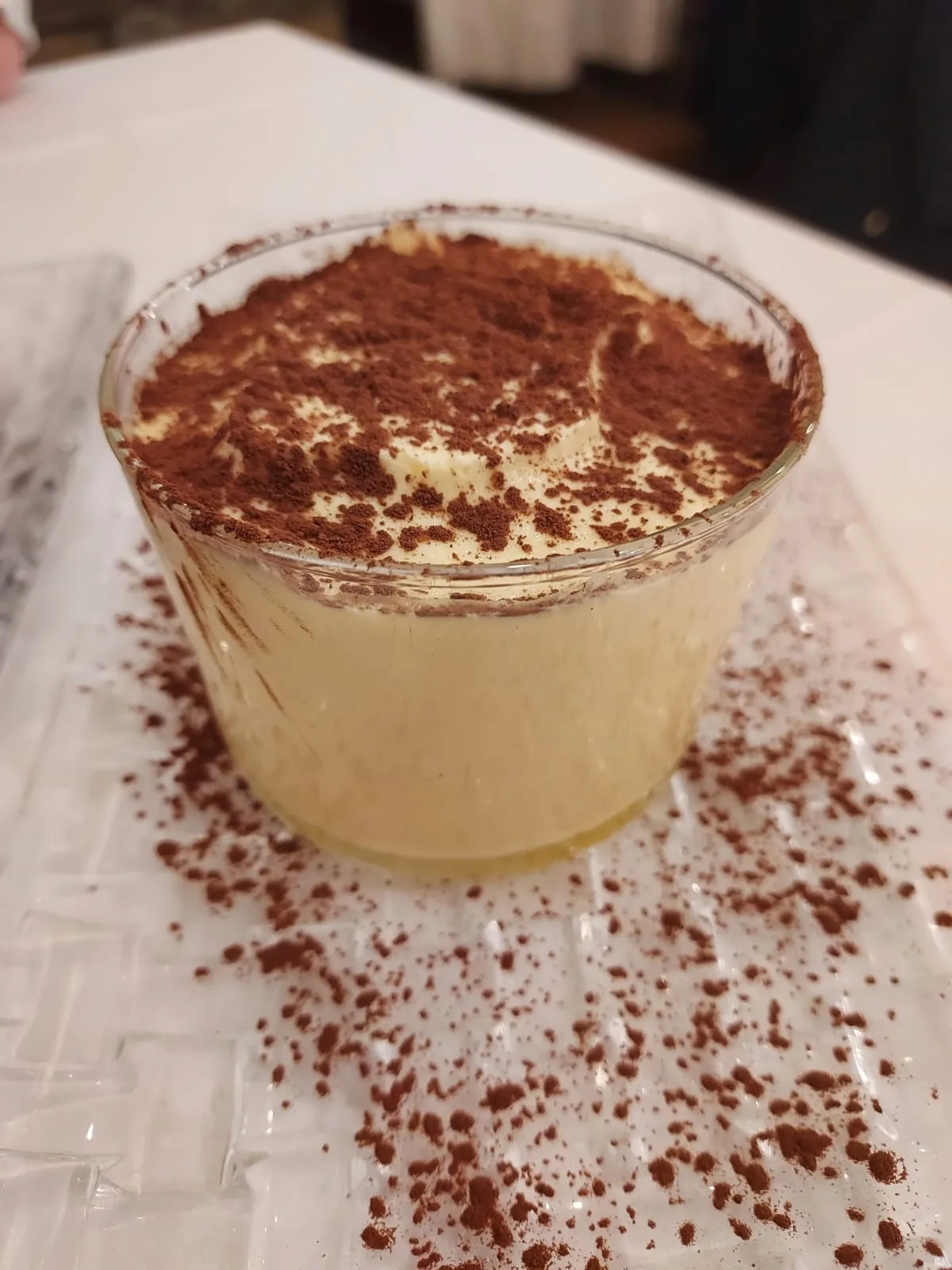 A glass of tiramisu with a dusting of cocoa powder