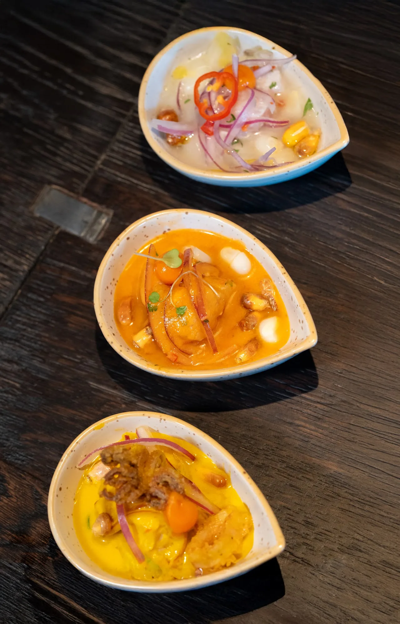 Three small bowls of Peruvian ceviche and tiradito