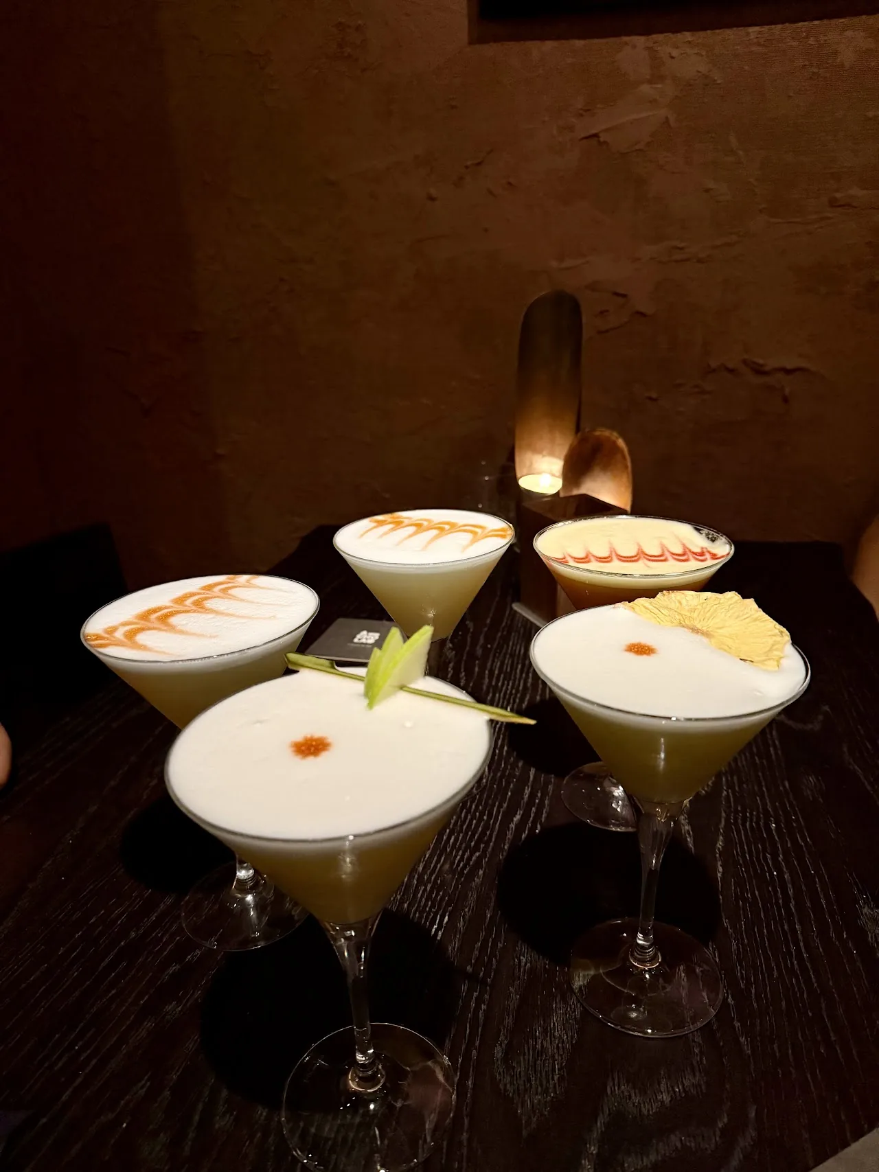 Three pisco sour cocktails in coupe glasses