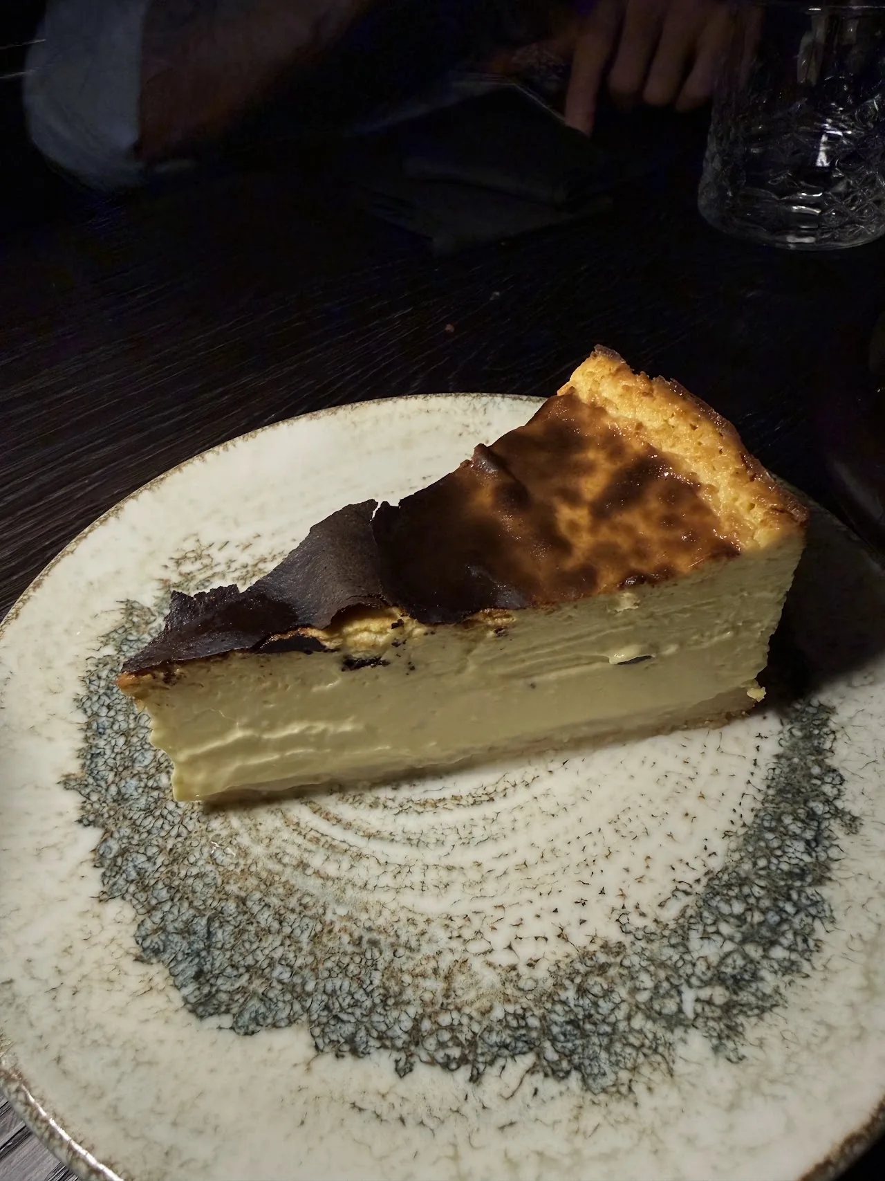 A slice of cheesecake drizzled with chocolate sauce