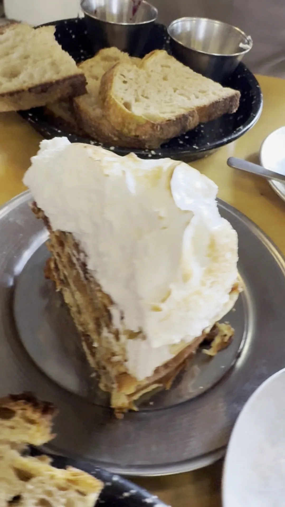 A slice of layered cake with cream frosting