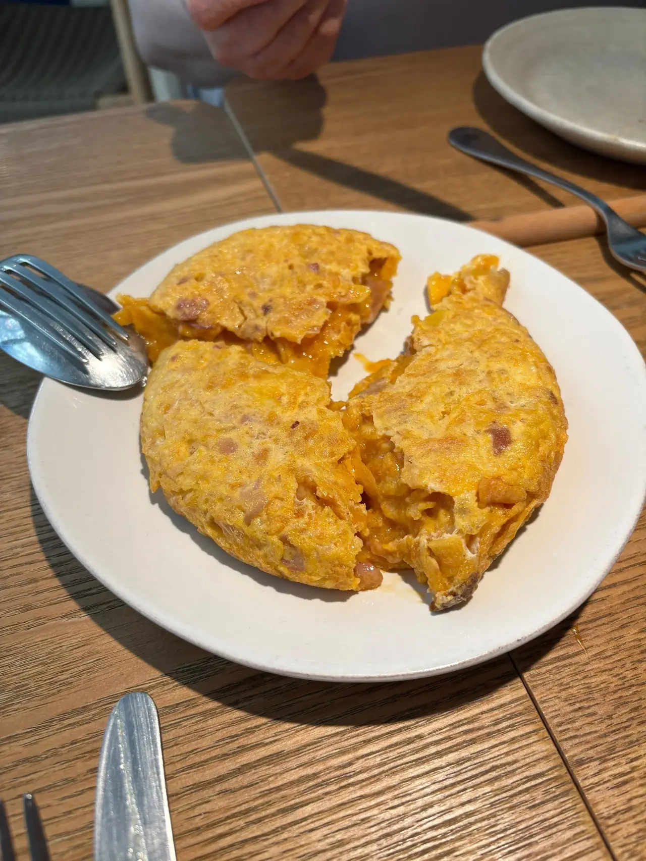Spanish tortilla filled with meat and vegetables, cut open on a plate