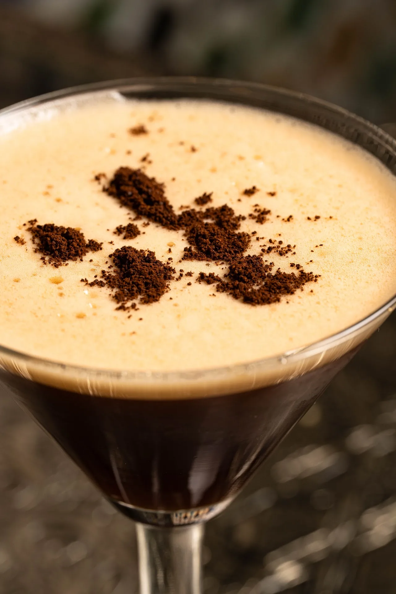 A coffee-topped cocktail in a martini glass