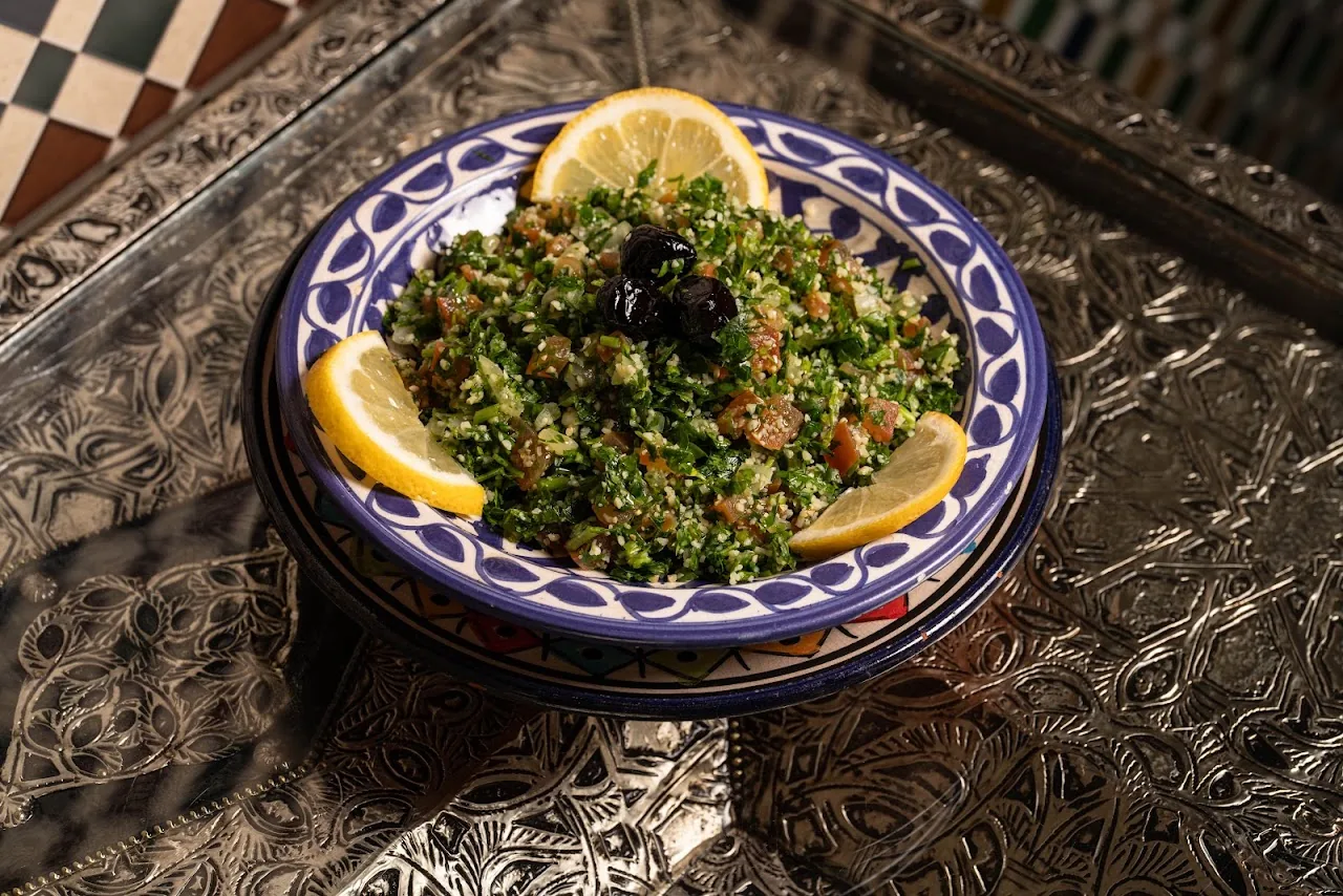 A tabbouleh salad garnished with lemon wedges