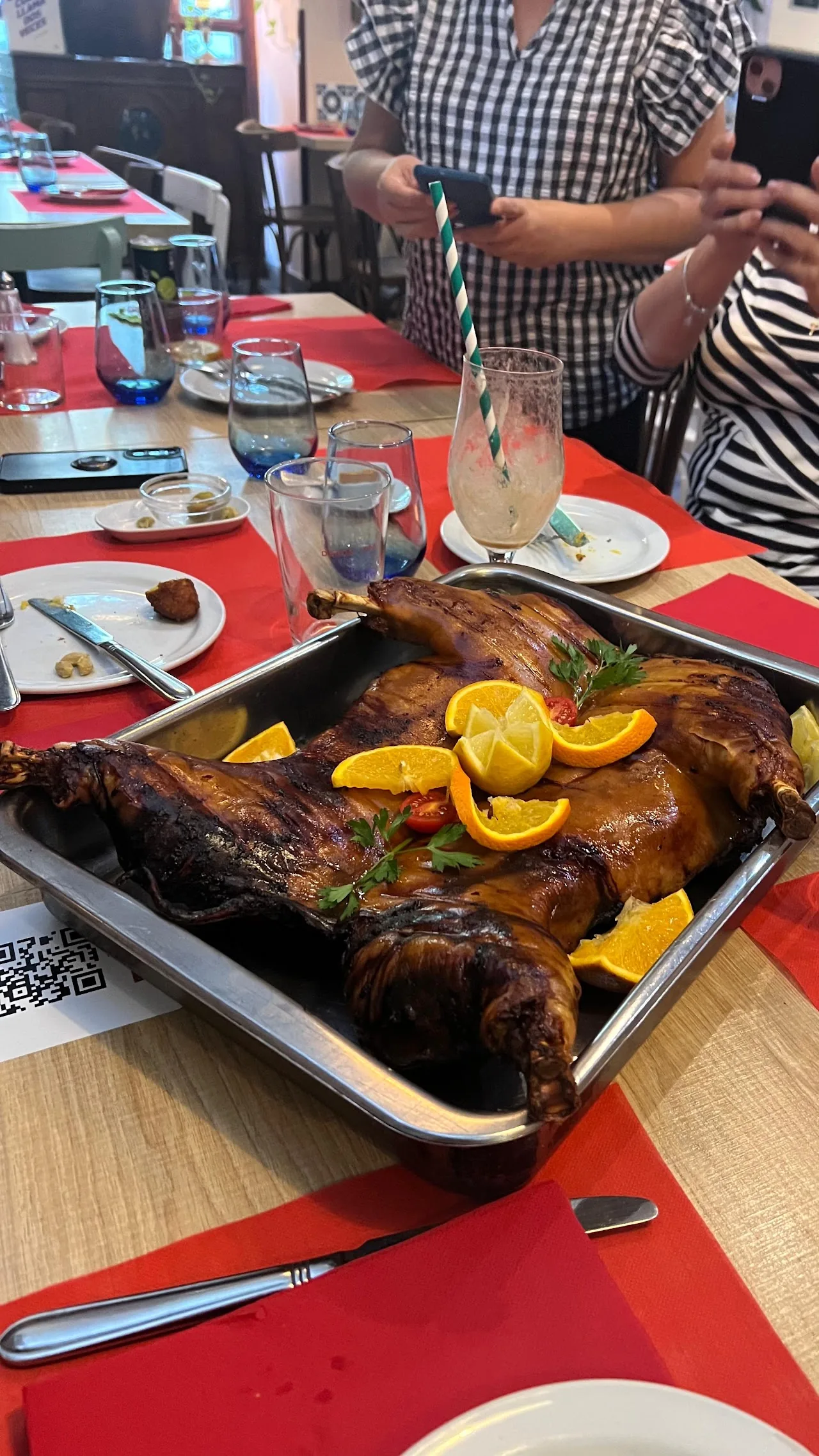 A whole roasted chicken served on a platter with orange garnish