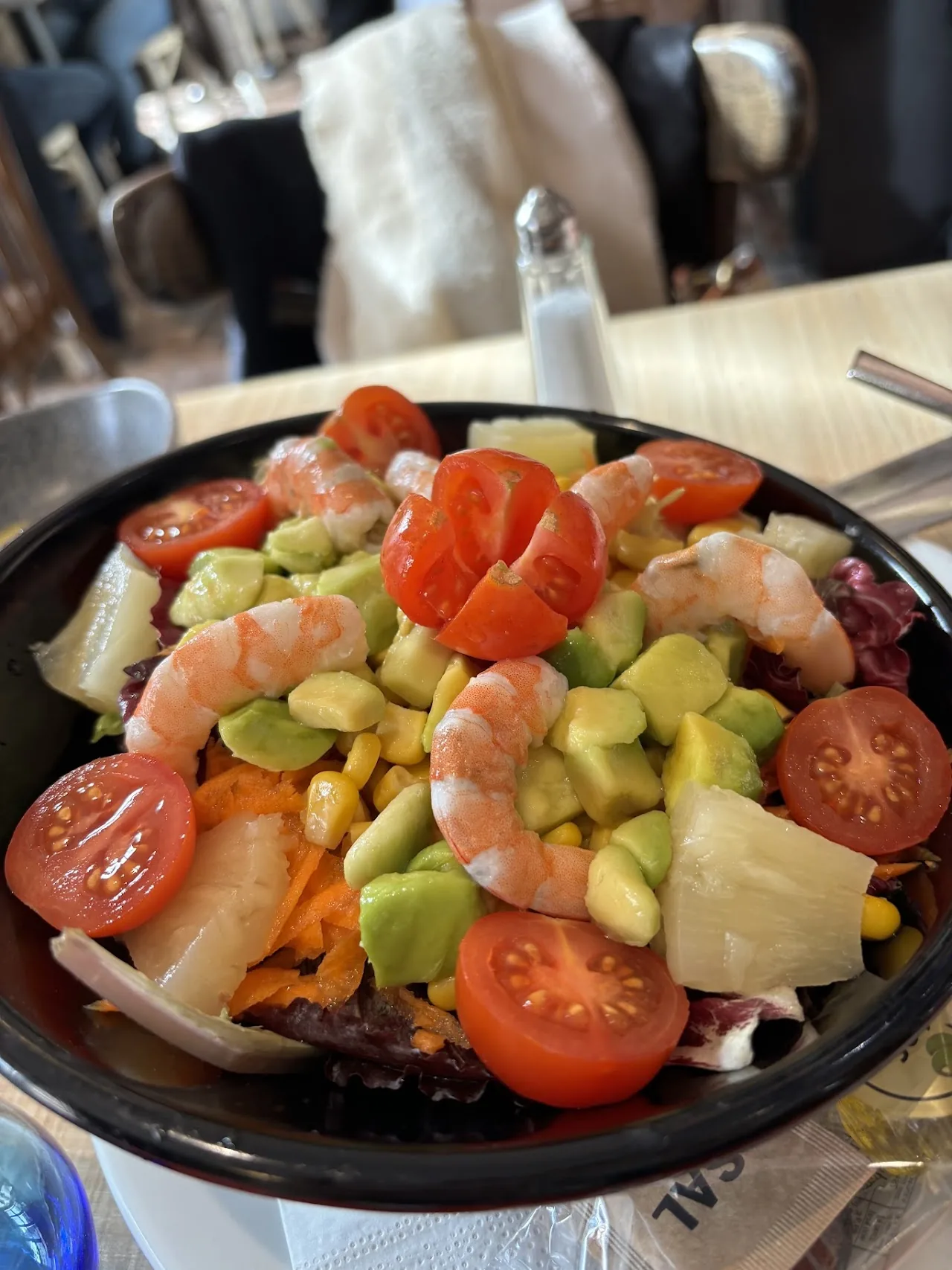 A salad with shrimp, avocado, and tomato