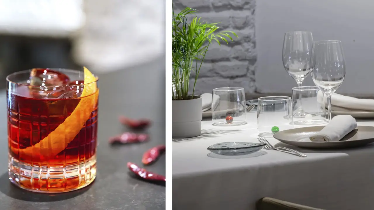 Negroni-style cocktail with orange peel garnish next to an empty place setting