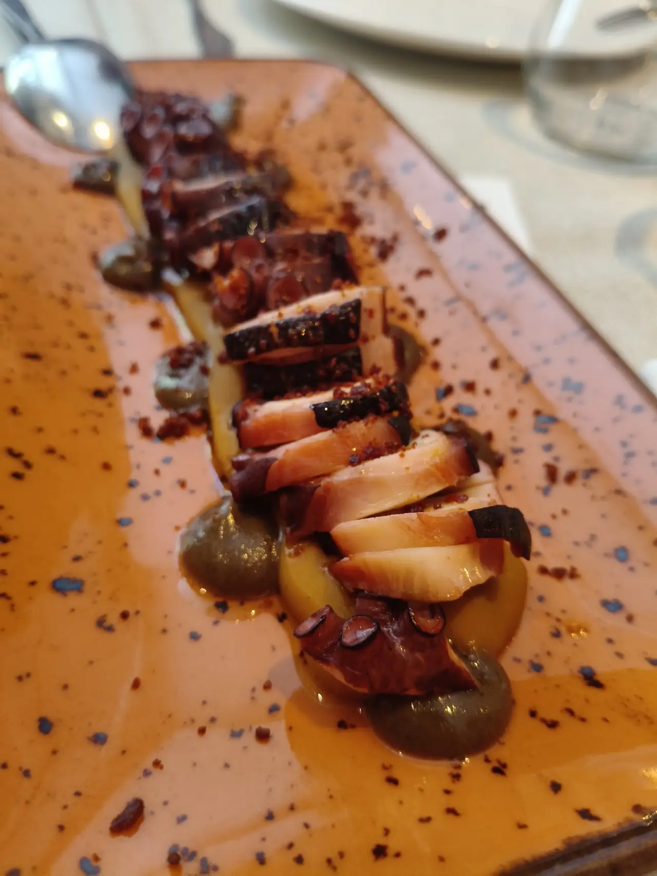 Sliced glazed pork belly arranged in a row on a plate.