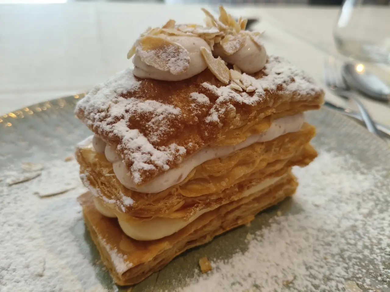 A layered mille-feuille pastry dusted with powdered sugar.