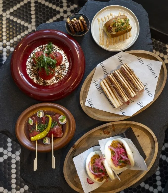 Small plates of food seen from above on a dark table