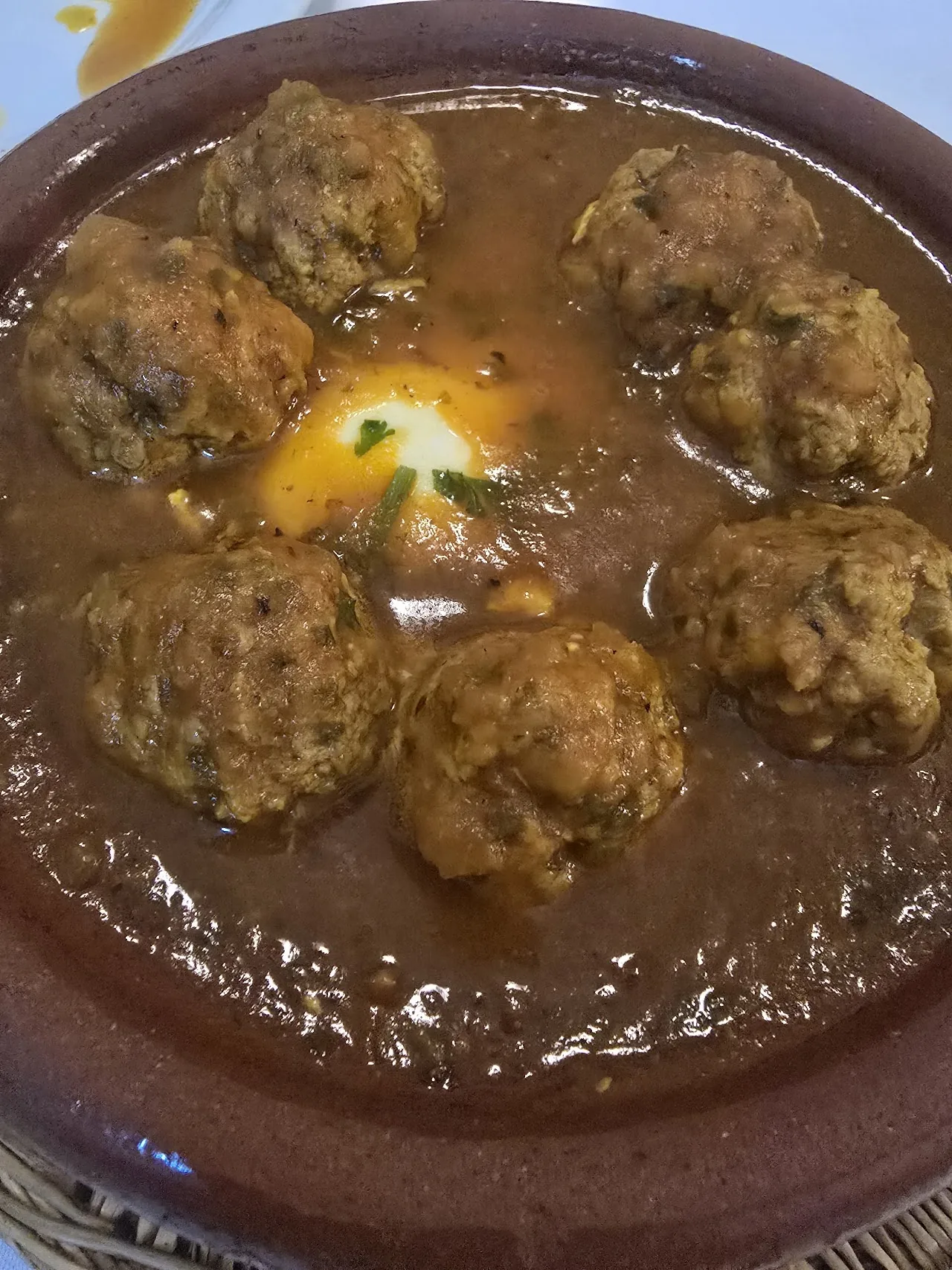 Moroccan meatballs in tomato sauce with a poached egg, served in a tagine