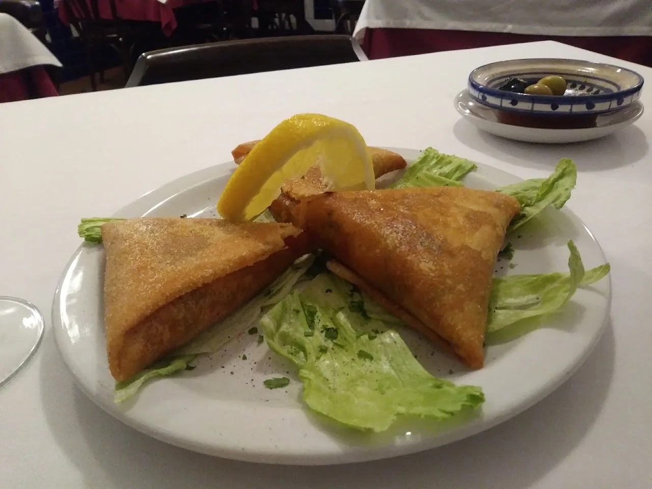 Two crispy filled pastries with lettuce and lemon
