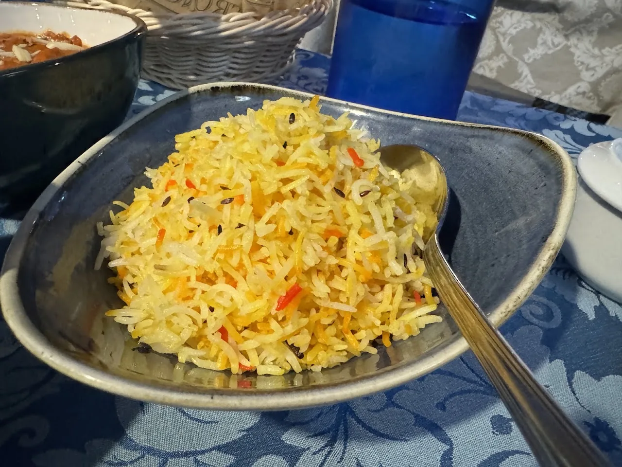 A bowl of yellow rice pilaf with a spoon