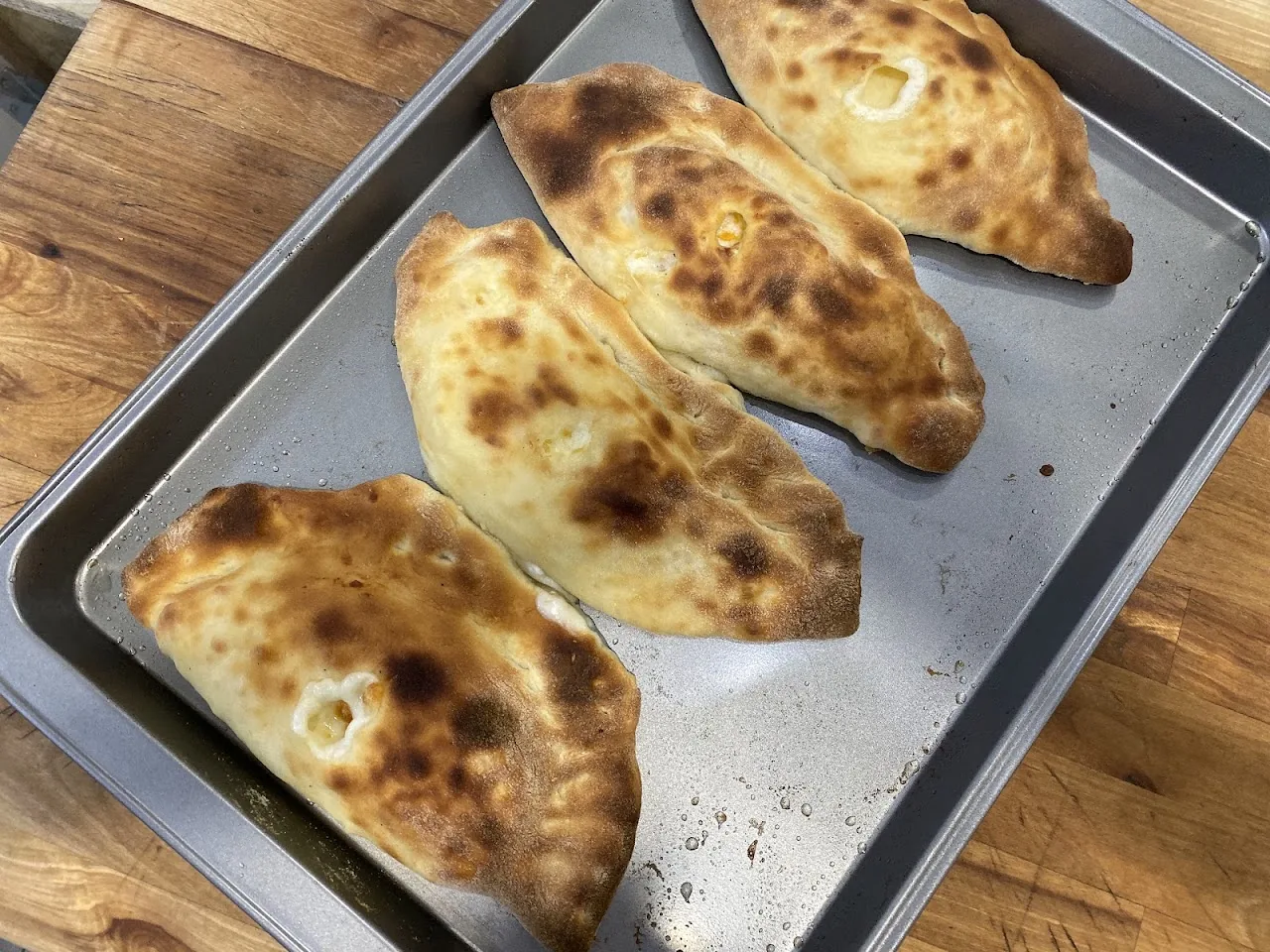 A tray of baked calzones