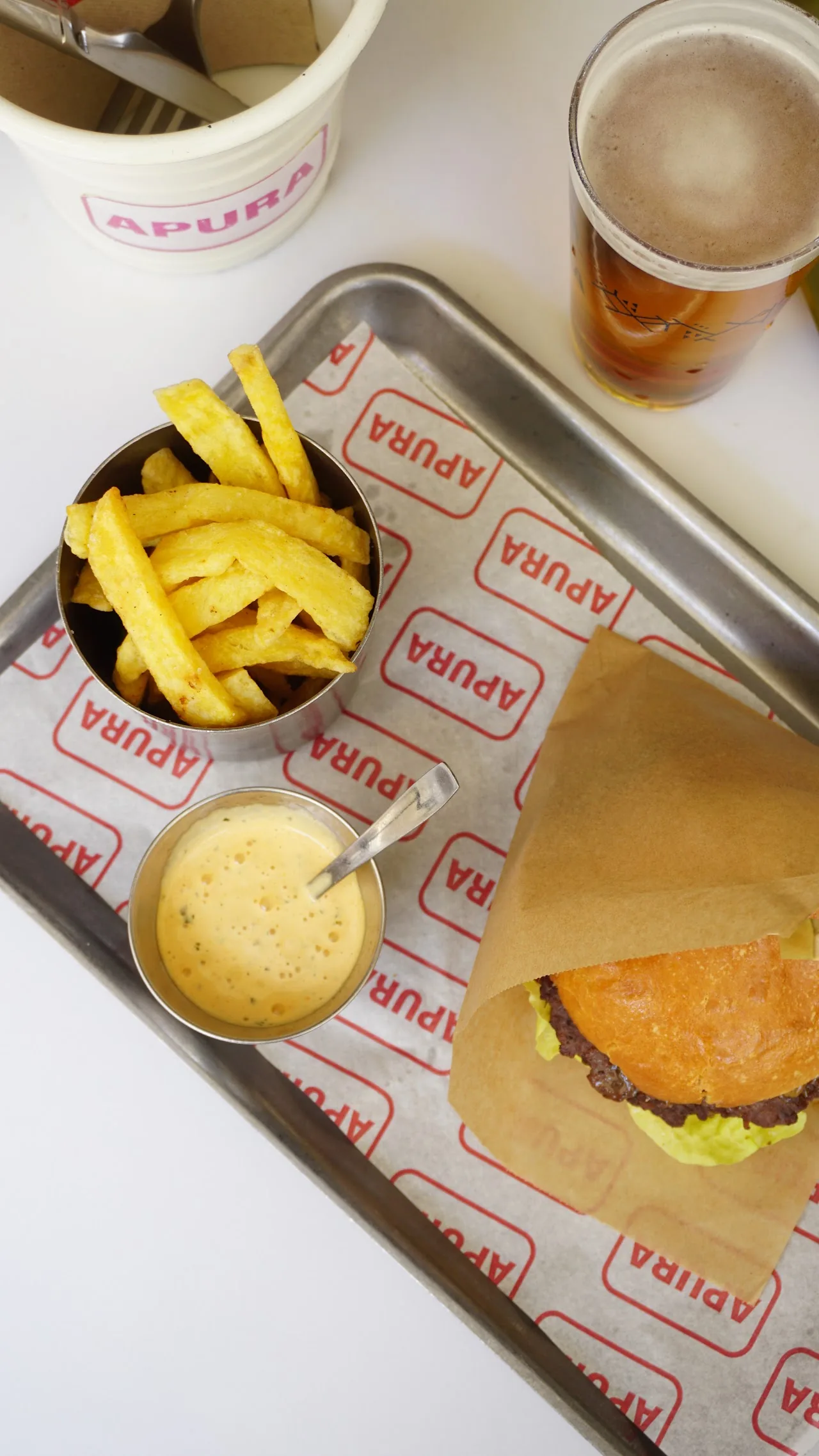 A tray with a burger, fries, and dipping sauces