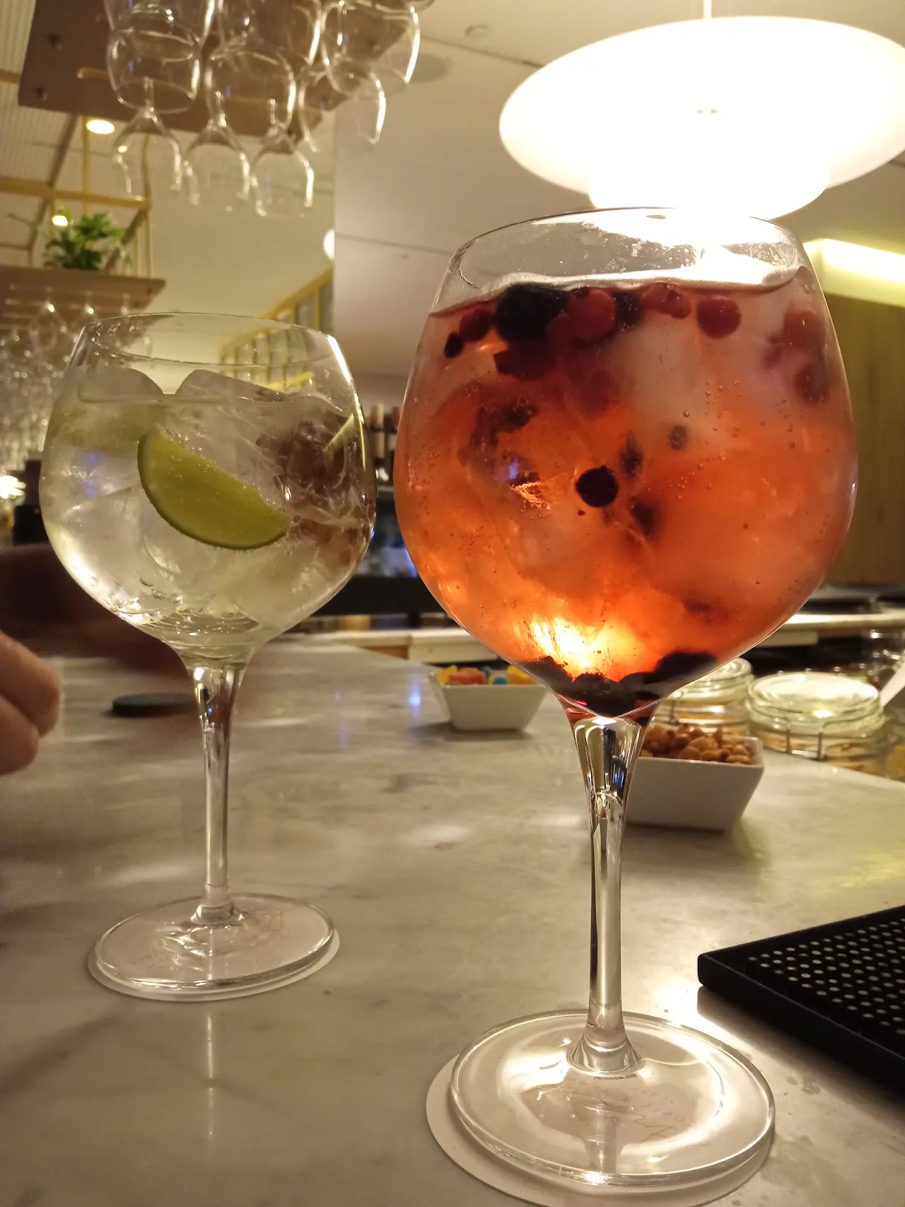 Two gin and tonic cocktails with orange garnish