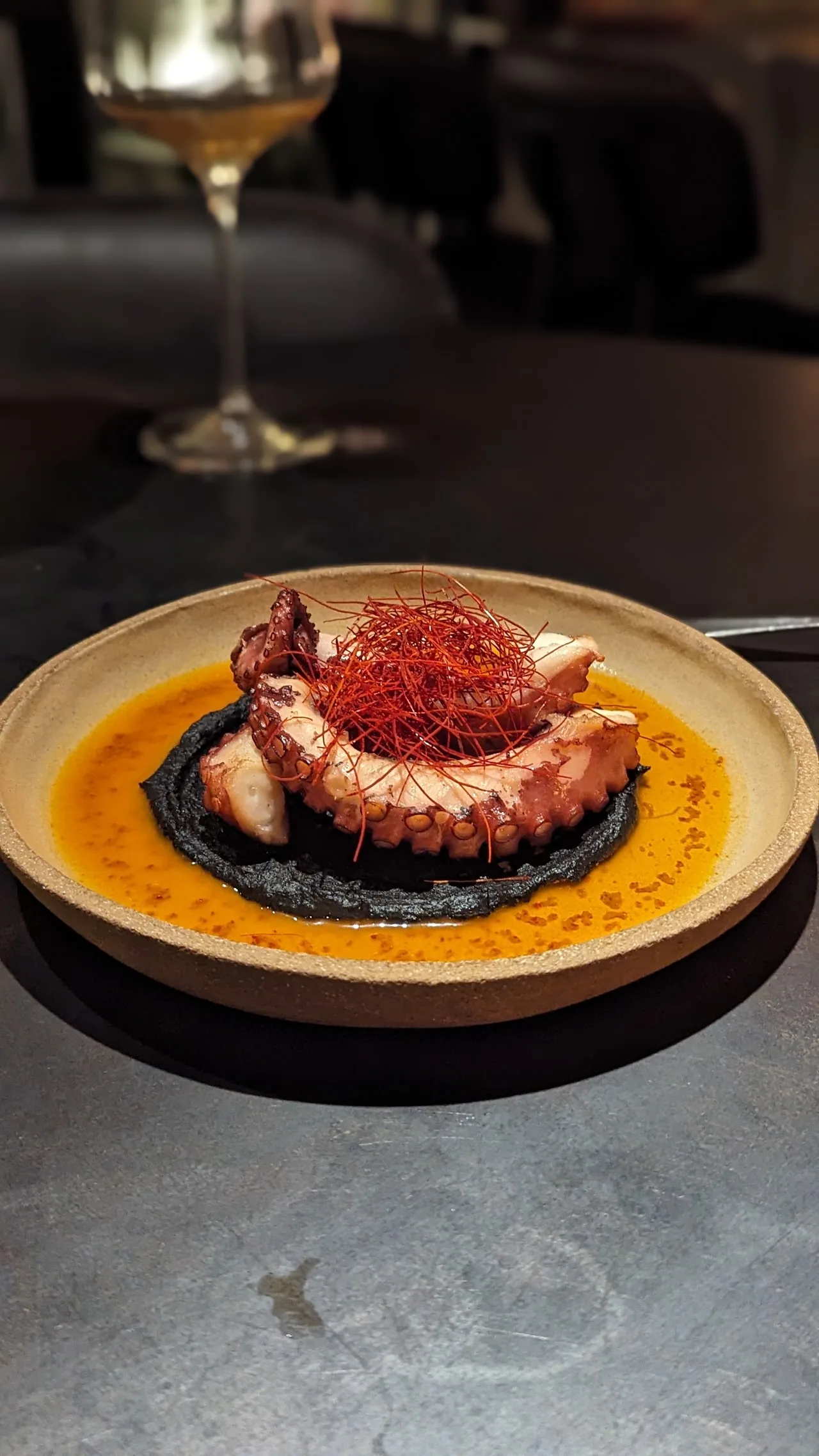 A langoustine dish in orange saffron sauce with a glass of white wine