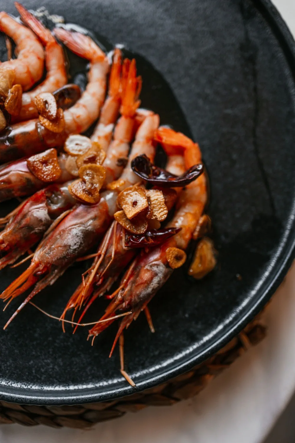 Grilled prawns piled on a black plate