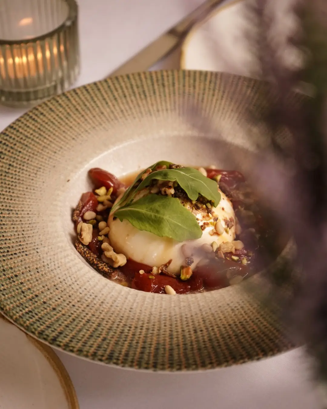Burrata topped with arugula, pistachios, and tomato compote