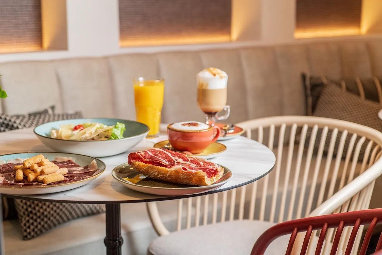 A breakfast spread of toast, pastries, orange juice and a latte