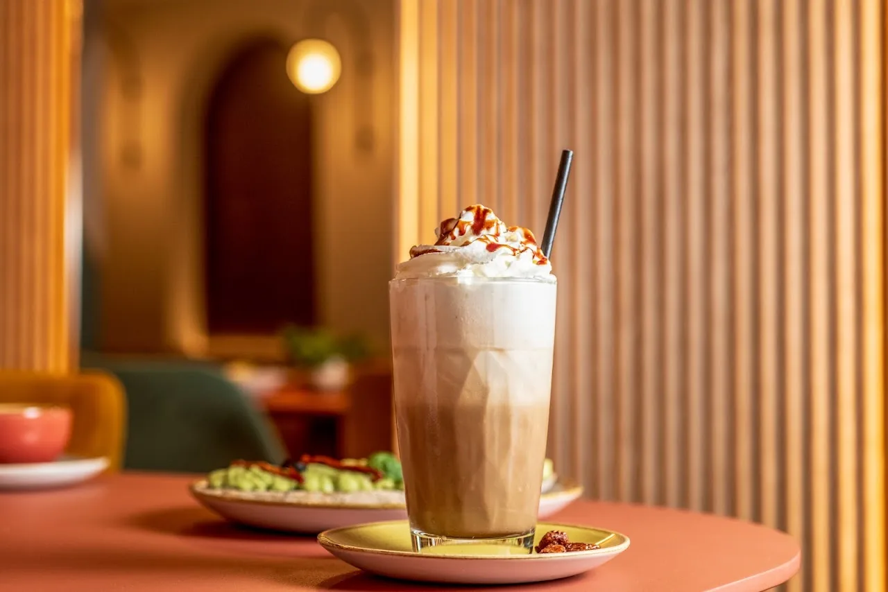 An iced coffee drink topped with whipped cream and sprinkles