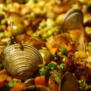 Close-up of seafood paella with clams, green peas and diced carrot