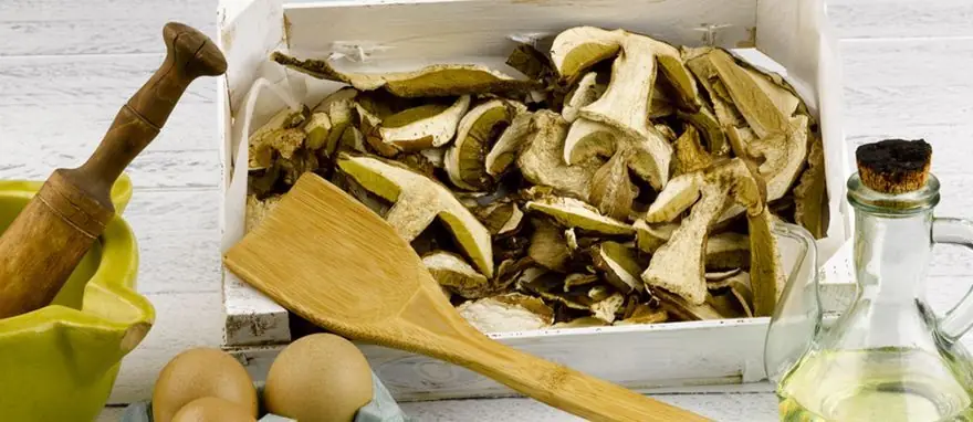 Sliced dried porcini mushrooms in a wooden crate with eggs and olive oil beside it, Arturo