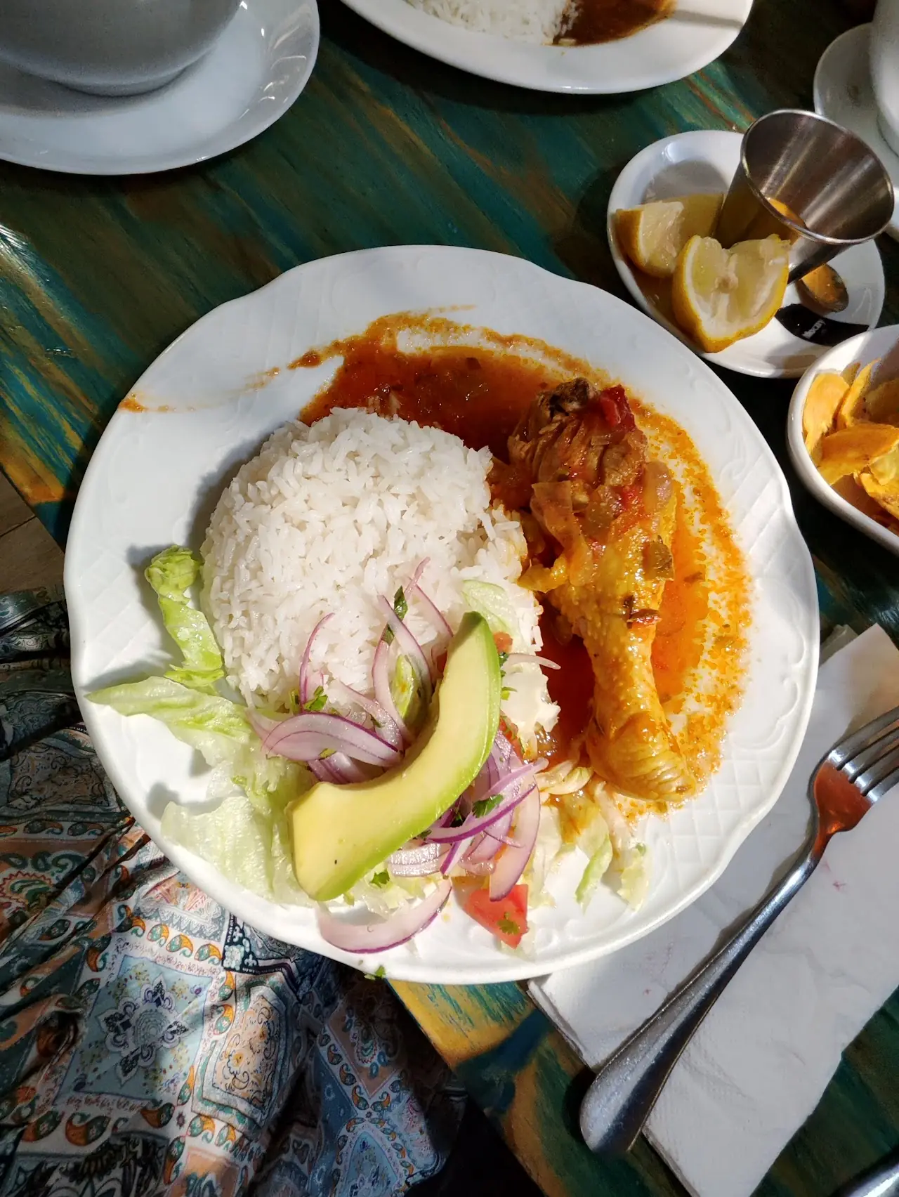 White rice with a braised stew, avocado and pickled red onion salad on a plate
