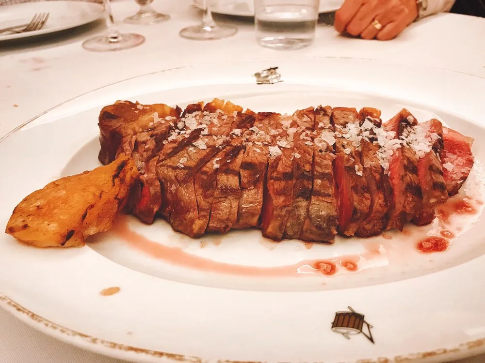 A sliced grilled steak fanned out on a white plate