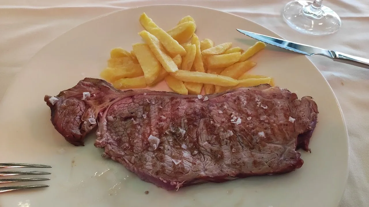 A grilled steak served with a side of French fries