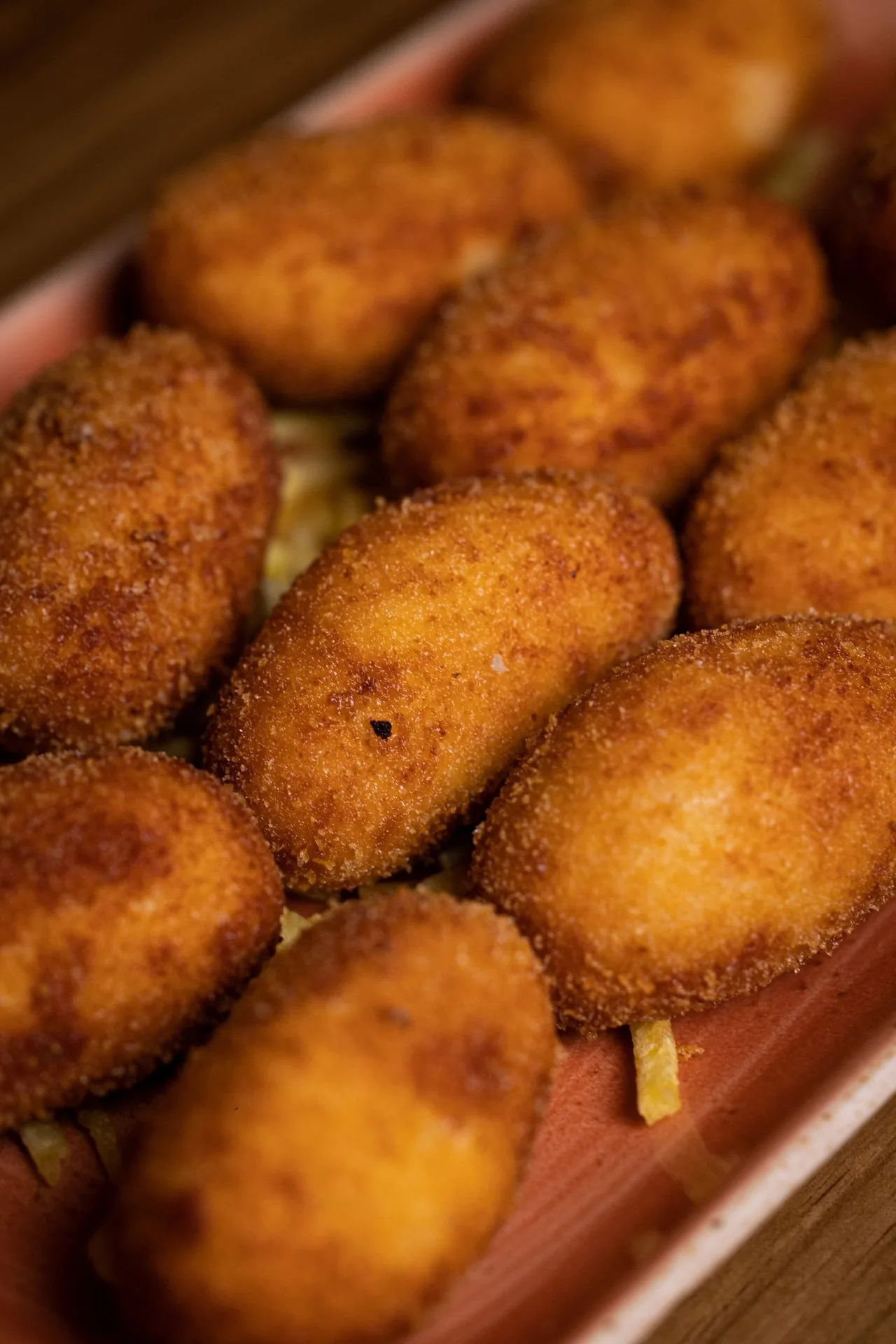 Golden croquettes stacked on a plate