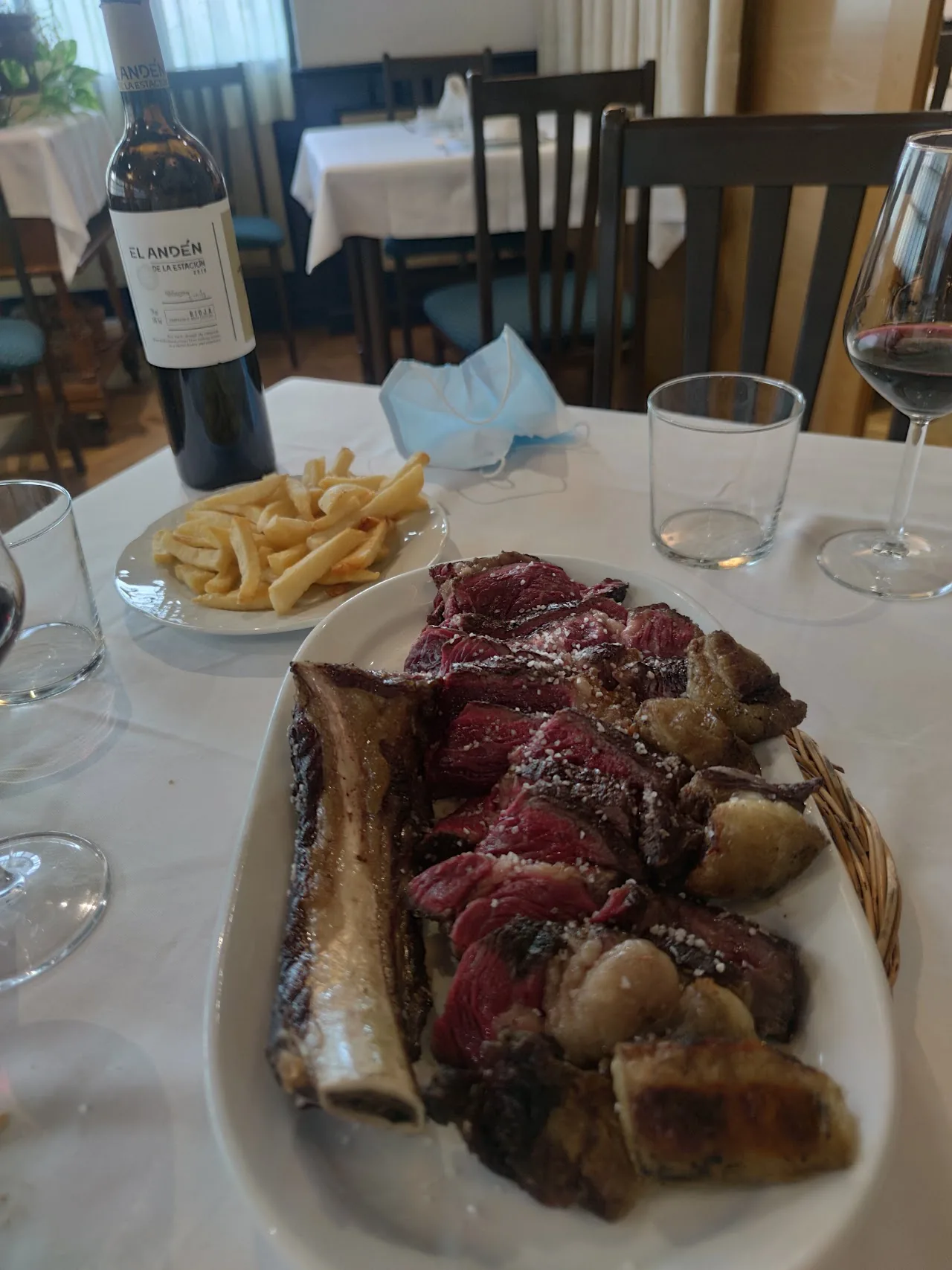 A bone-in ribeye steak with sautéed mushrooms on a platter
