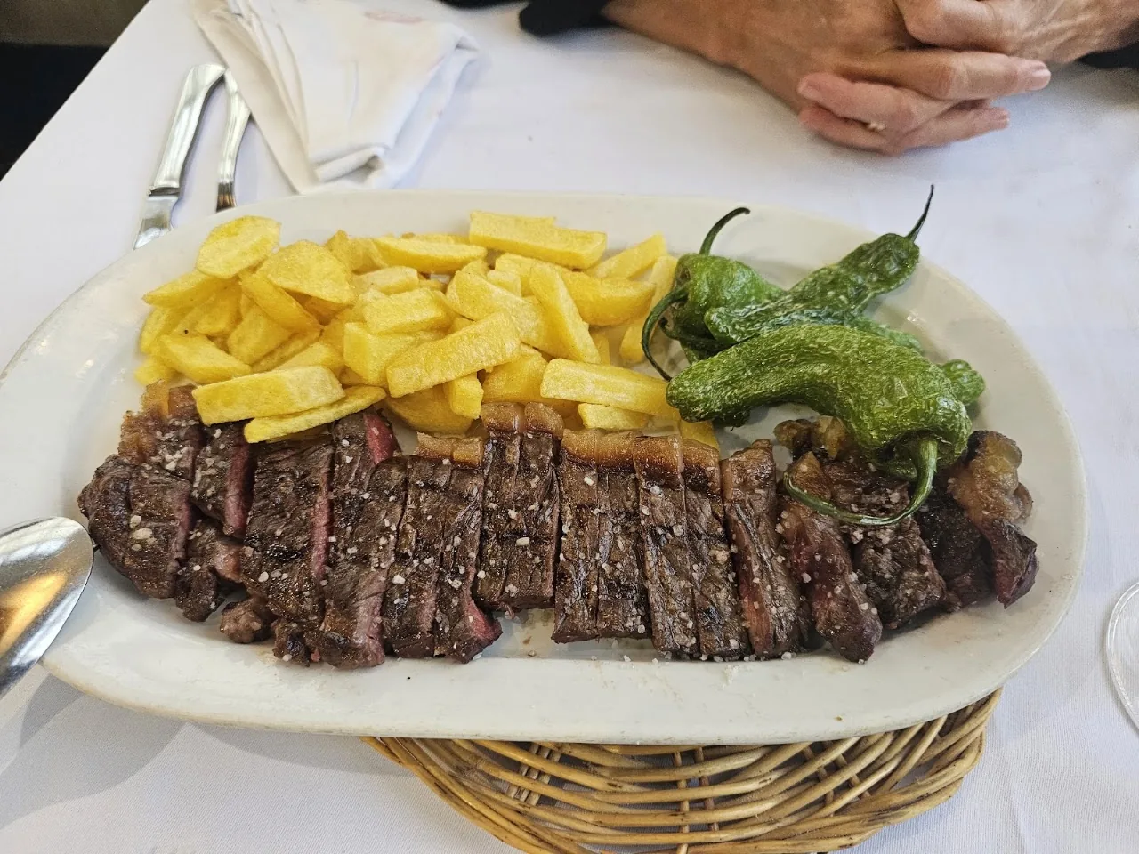 A grilled steak with fries and a grilled green pepper