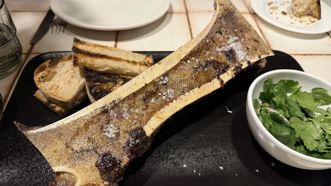 A charred bone marrow with herb garnish