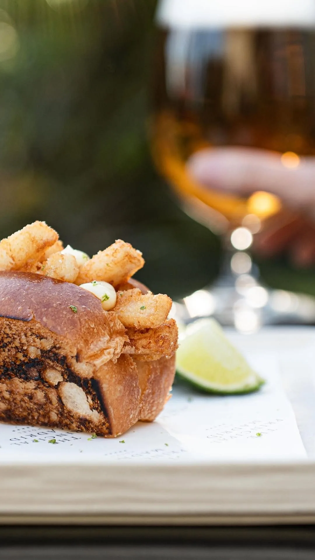 Crispy pieces of food with a lime wedge and a drink