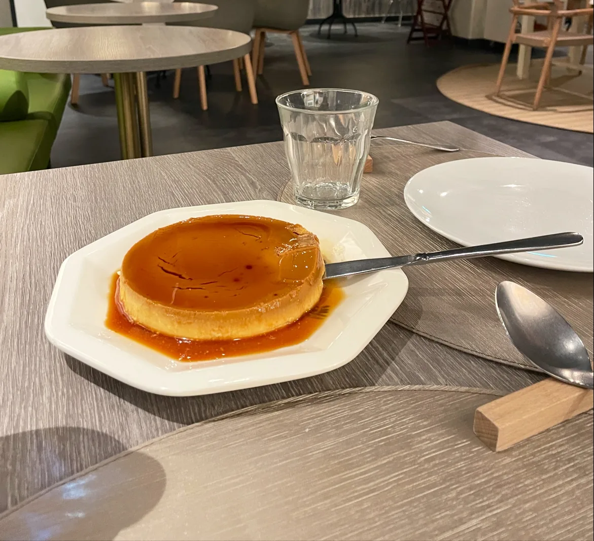 A creme caramel flan on a plate at a restaurant table