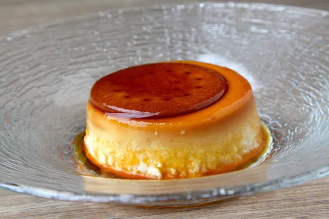 A close-up of a creme caramel flan with caramel sauce