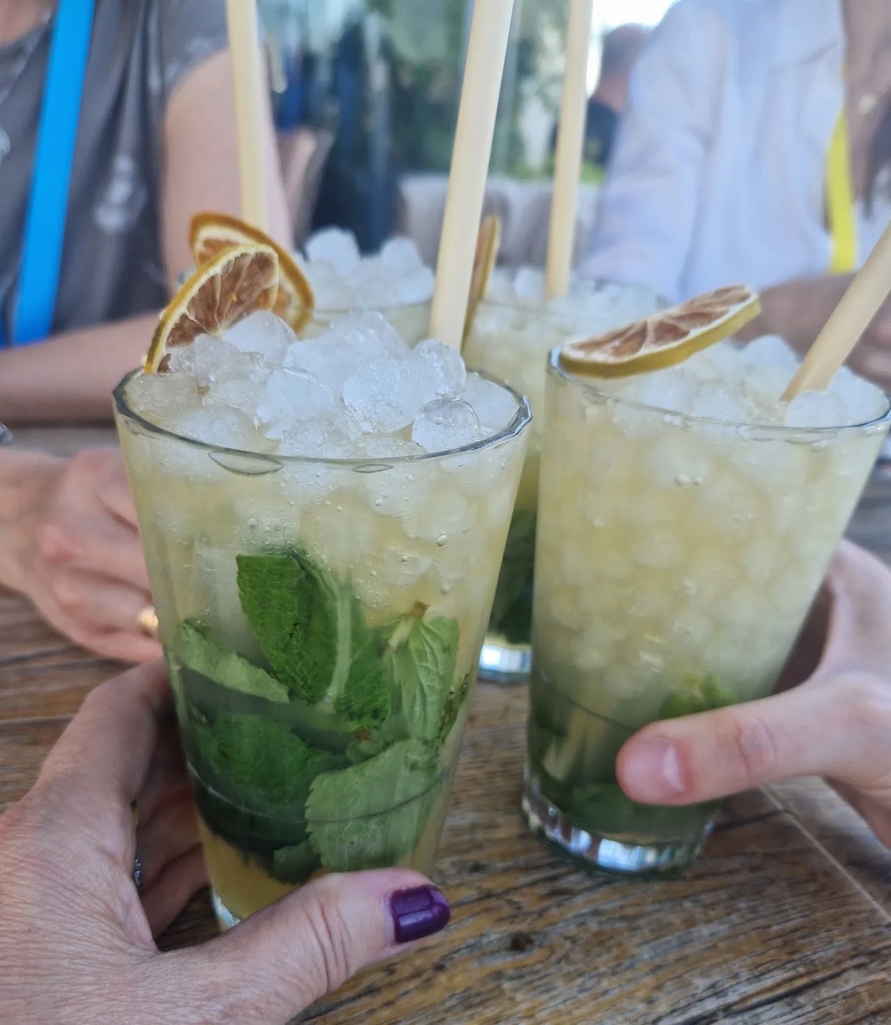 Two mojito cocktails garnished with mint and orange slices