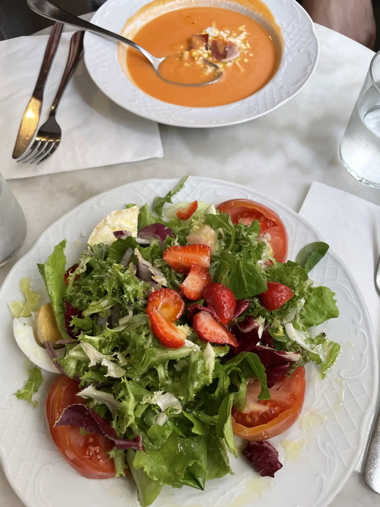 Gazpacho and a mixed green salad with strawberries and tomato