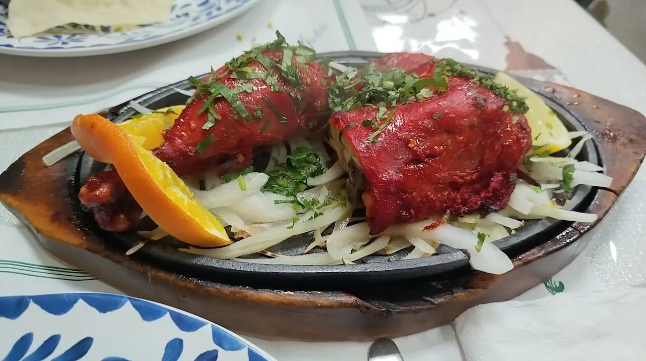 Tandoori dishes served on a sizzling platter with onions and lemon