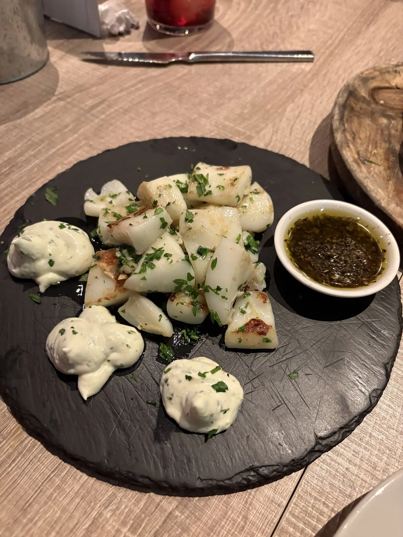 A plate of dumplings with a side of dipping sauce