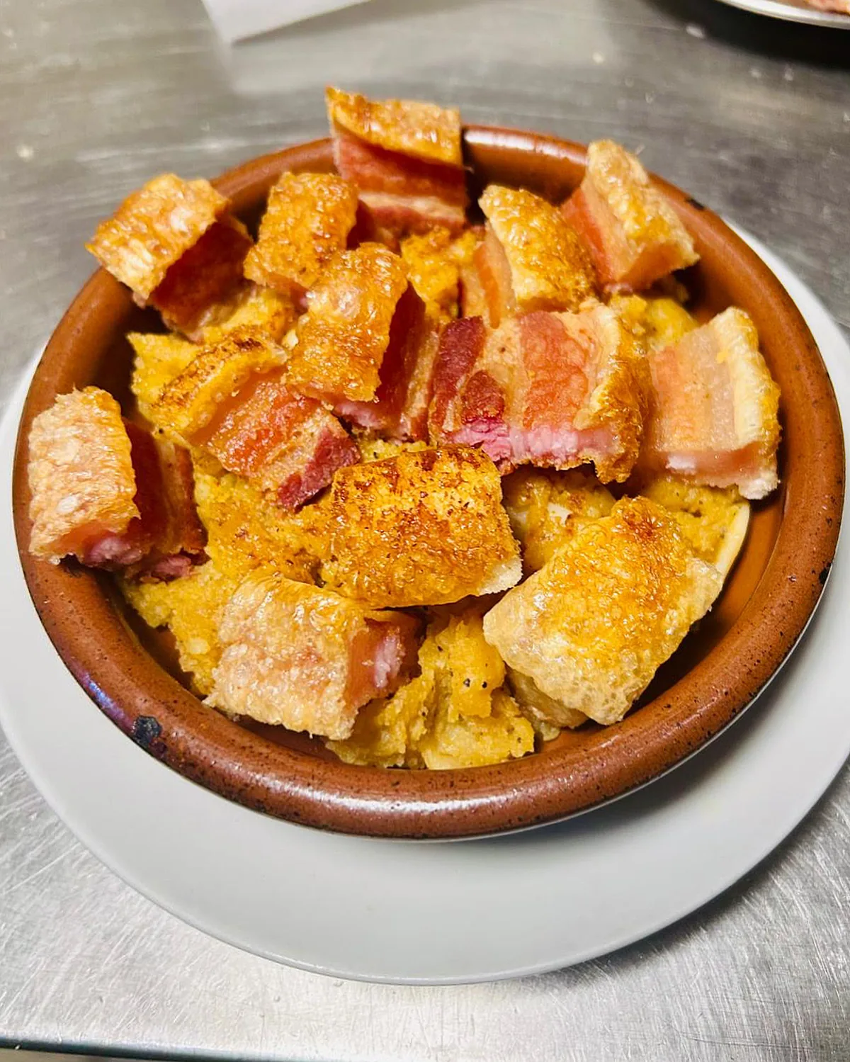 A slice of bread topped with melted cheese and ham