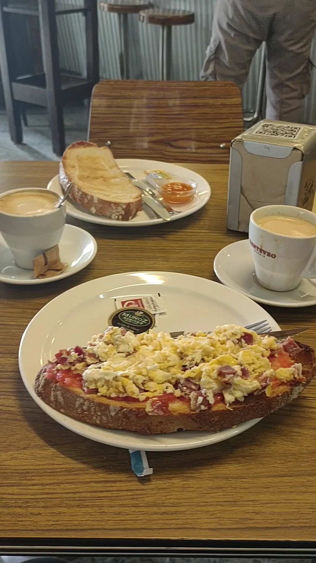 A slice of toast with tomato and scrambled egg on a plate