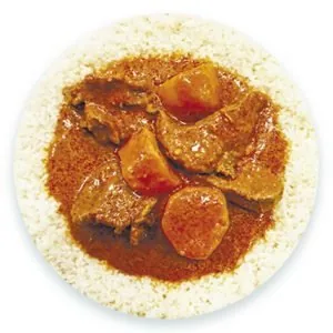Chunks of meat and carrot in a deep red stew spooned over a ring of white rice