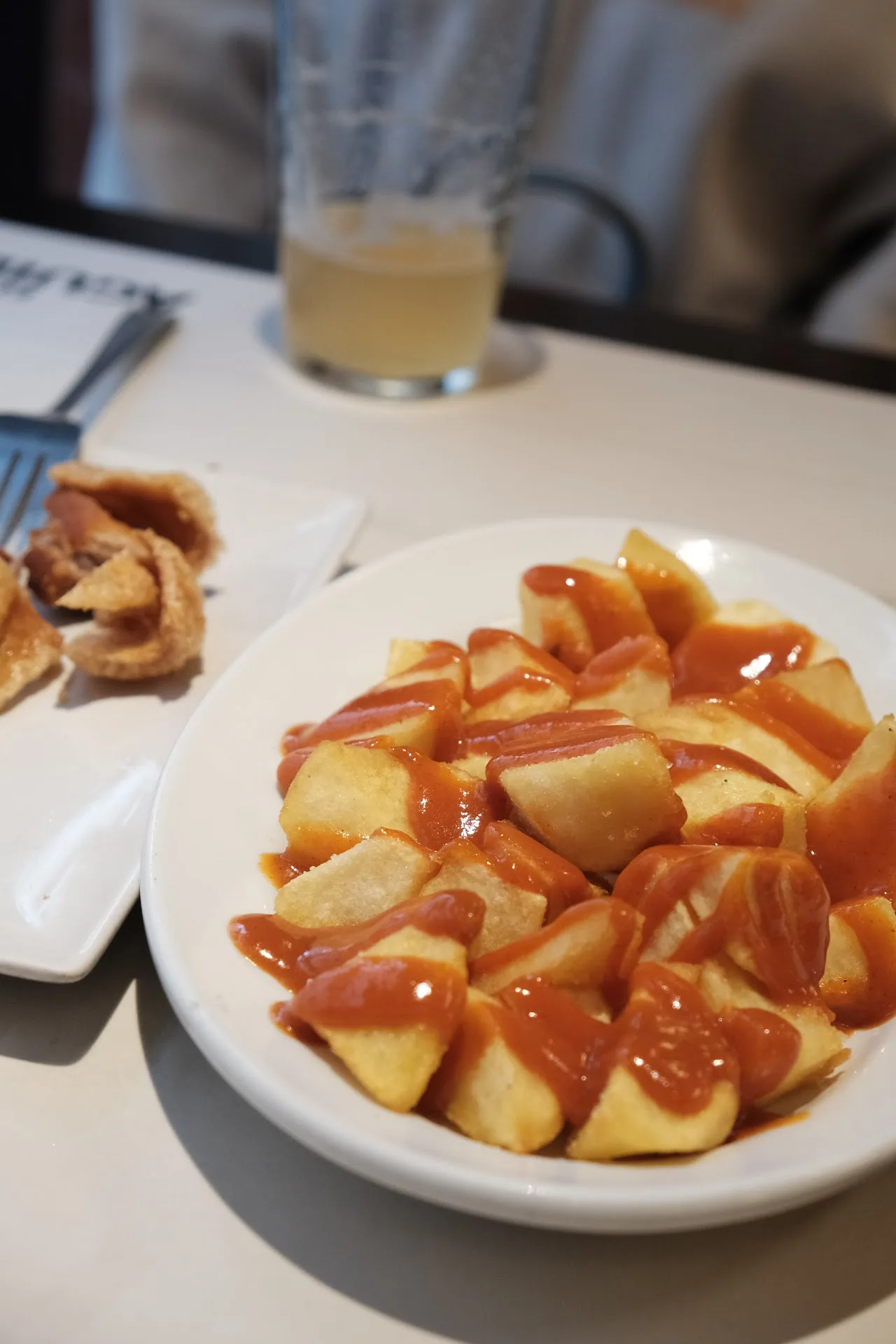 A plate of fried bites drizzled with a caramel-colored sauce